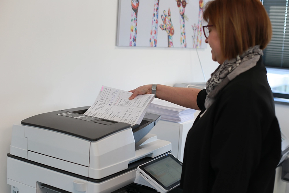 Une employée réalise des photocopies sur une imprimante Ricoh